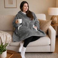 mujer sentada en la sala de su casa con la sudadera gris de cobija 